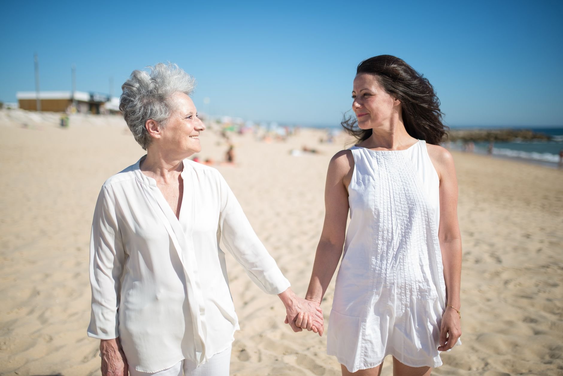A mother and daughter hold hands warmly in soft afternoon light